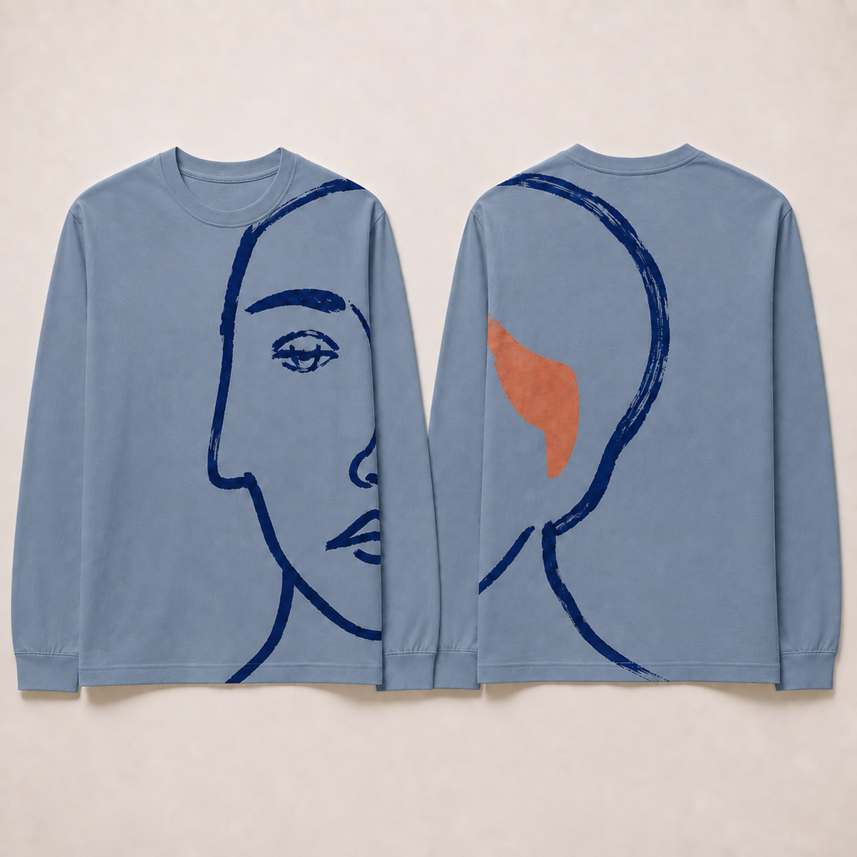 Front and back of a dusty-blue long-sleeve tee with the same partial ink portrait and rust accent continuing around one side.