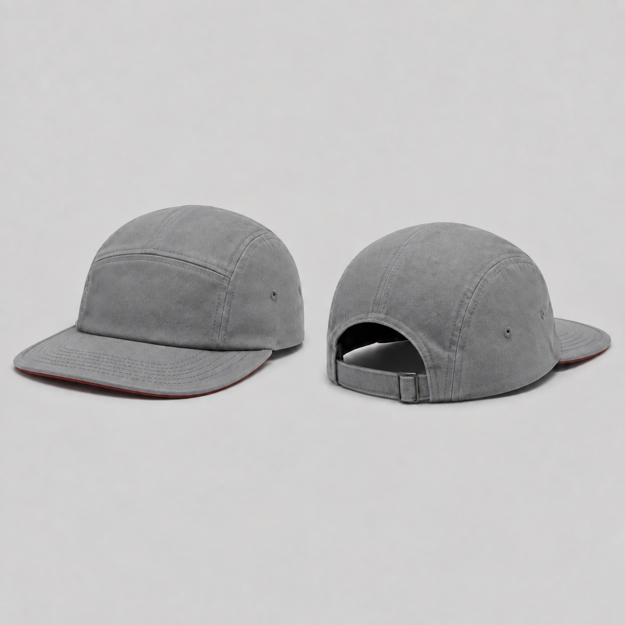 Front and rear three-quarter views of a warm-gray low-profile cap with the same broad shallow brim and brick-red underside.