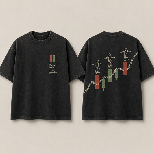 Front and back of a washed-black oversized tee with a hold-position chest notice and balancing figures moving across market bars.