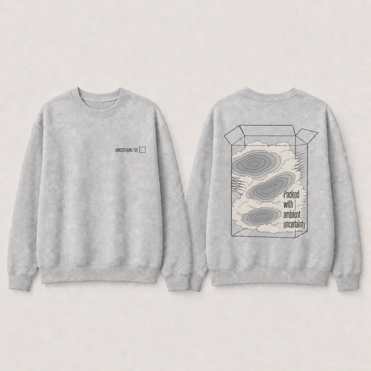 Heather-gray crewneck with packed fog and disconnected pressure cells beneath UNCERTAIN 01.