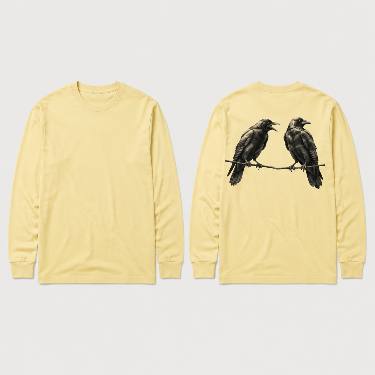 Front and back concept views of a pale-butter long-sleeve tee with one crow calling toward a second crow looking away, both perched on a thin line across the upper back.