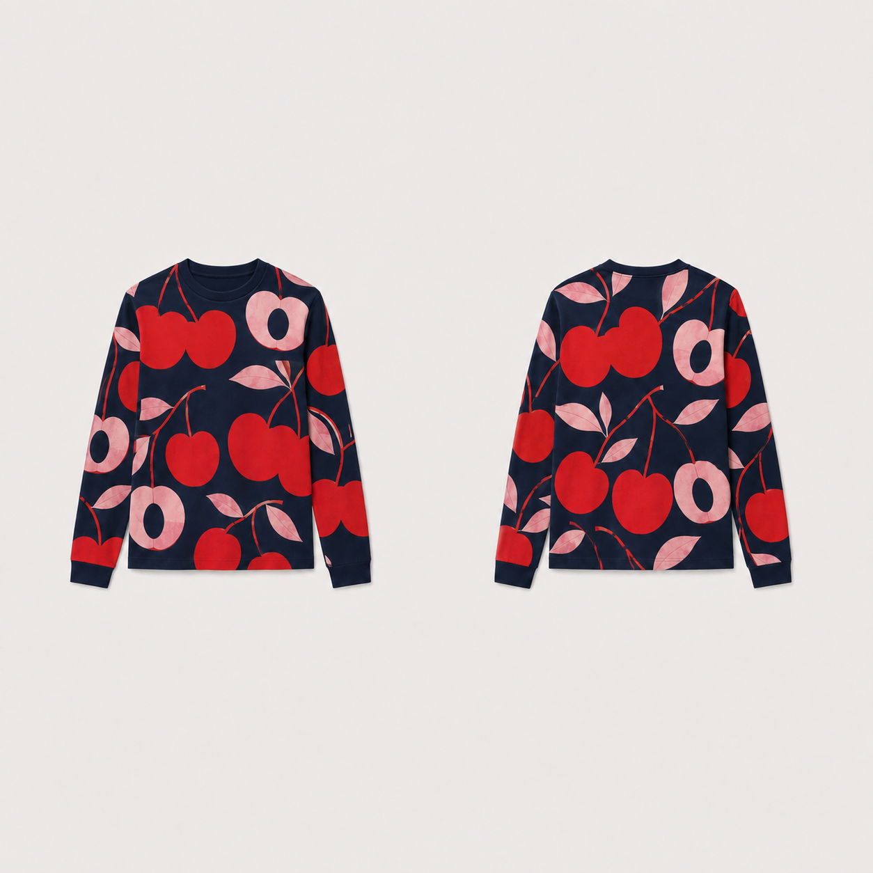 Ink long-sleeve tee with large cherry red fruitlike forms, pale pink halves and leaves across front, back and sleeves.