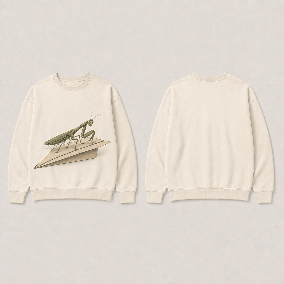 Front and back of a warm-chalk crewneck with an olive praying mantis and cream paper airplane on the front and a plain back.