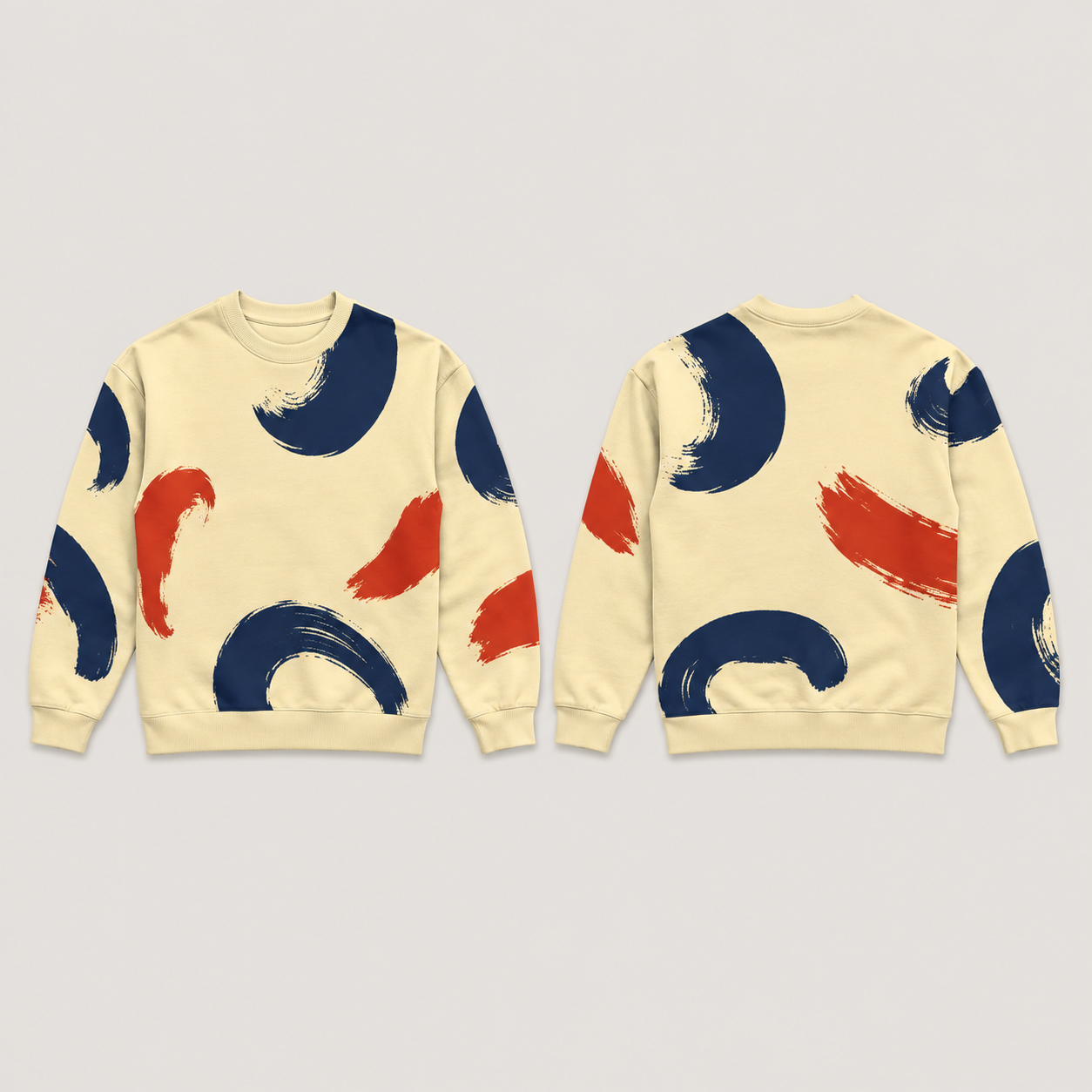 Front and back of a butter crewneck sweatshirt with large open navy brush crescents and red counterstrokes, and plain butter neck, cuffs and hem.