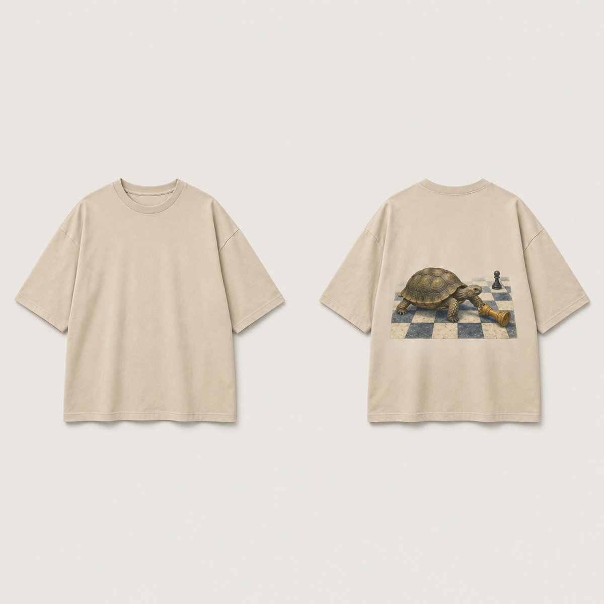 Front and back of a warm-sand oversized tee; a tortoise approaches a fallen chess piece on a small checkerboard patch on the back.