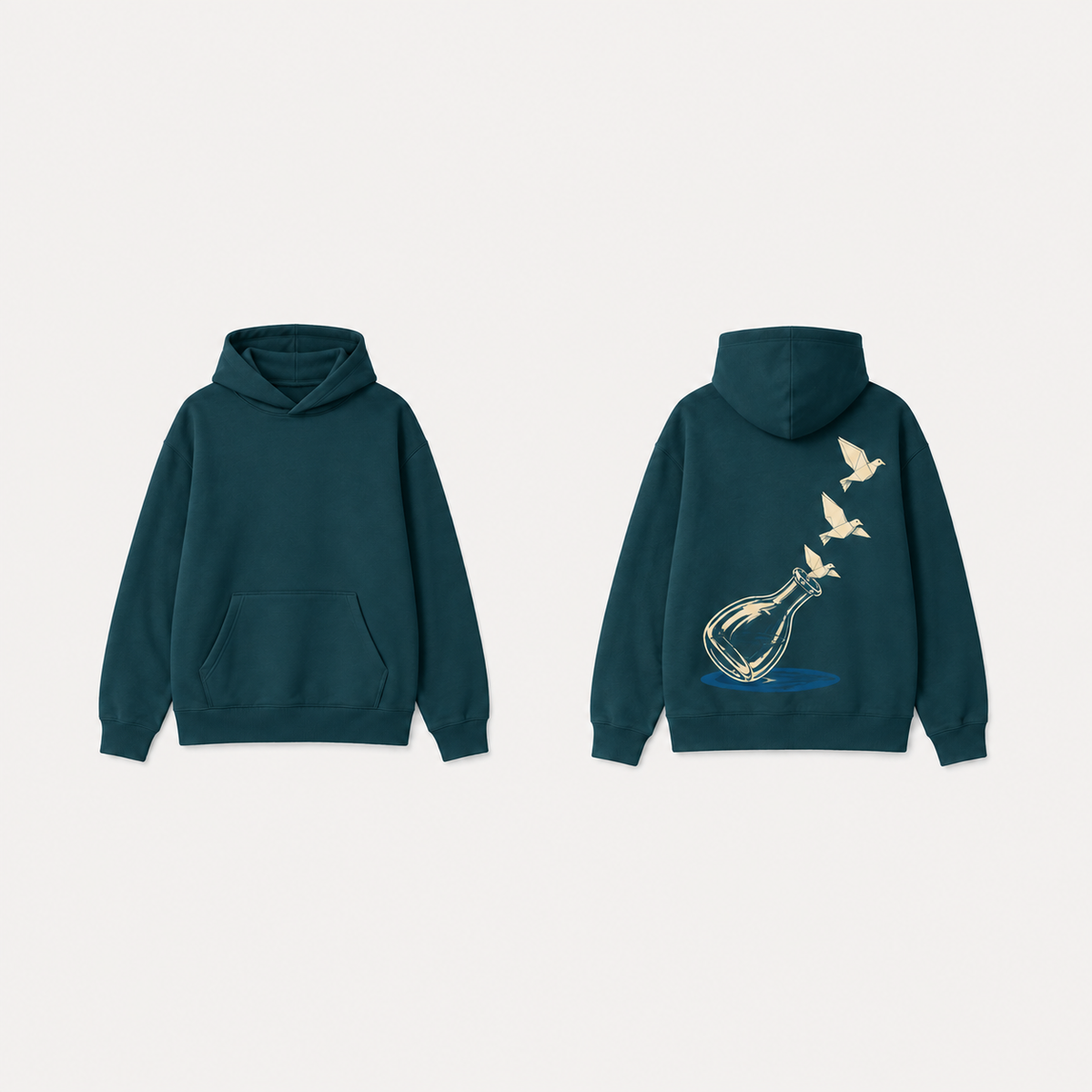 Deep teal pullover hoodie with a tilted glass carafe and three cream paper birds rising from its rim on the back; plain front.