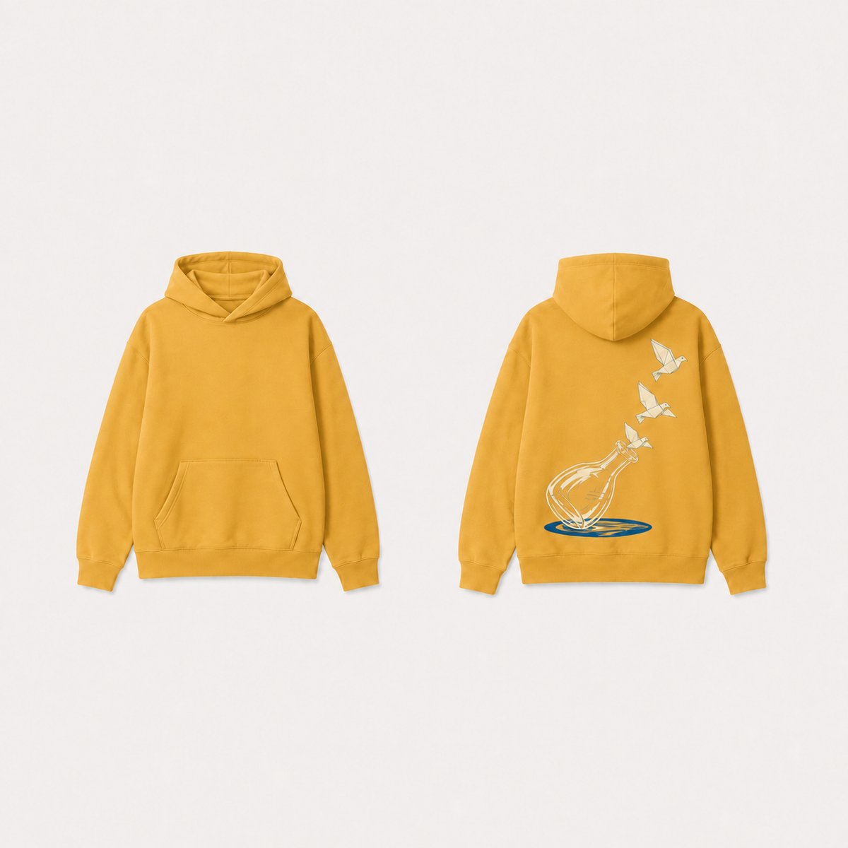 Muted marigold pullover hoodie with the same empty carafe, three paper birds and cobalt shadow.