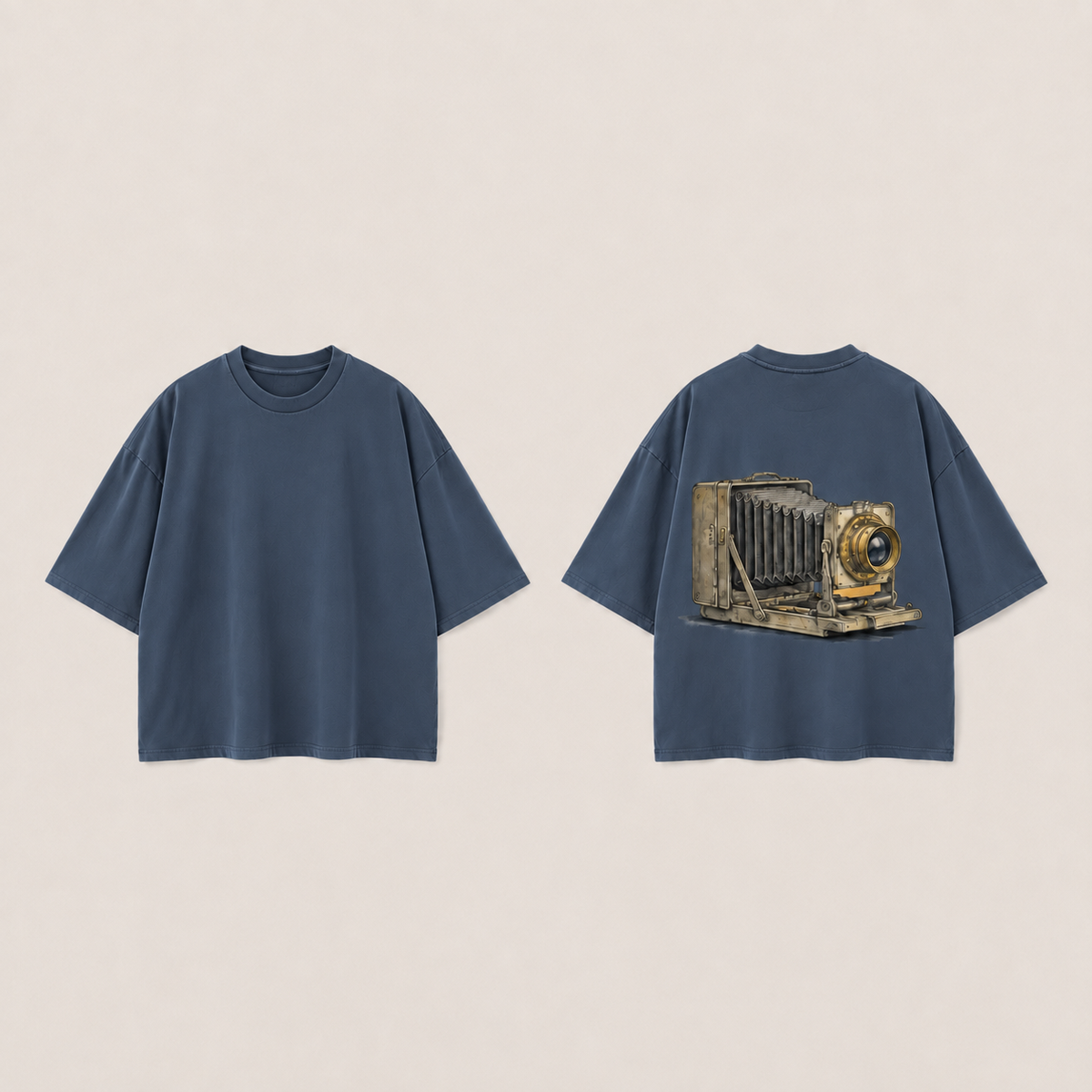 Front and back of a storm blue oversized tee, with the same folding bellows camera illustration on the back.