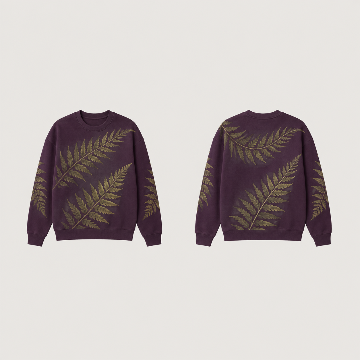 Front and back of a deep-plum crewneck with large diagonal moss-green fern-like fronds across the body and sleeves, and plain plum ribs.