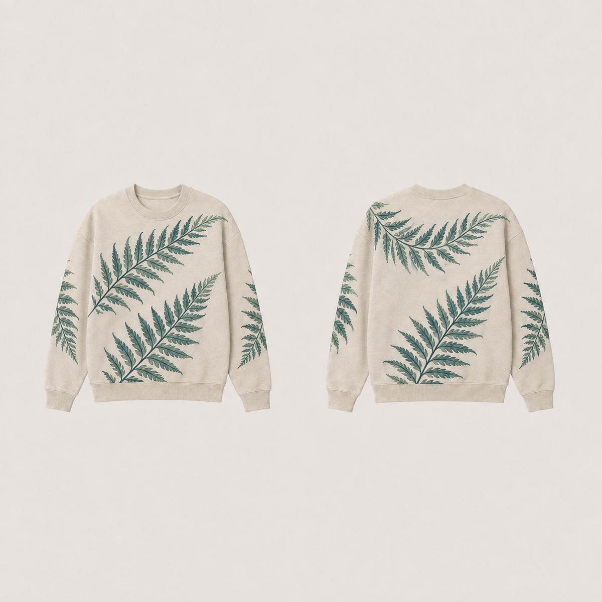 Front and back of an oat crewneck with large dark-teal and sage fern-like fronds and plain oat ribs.