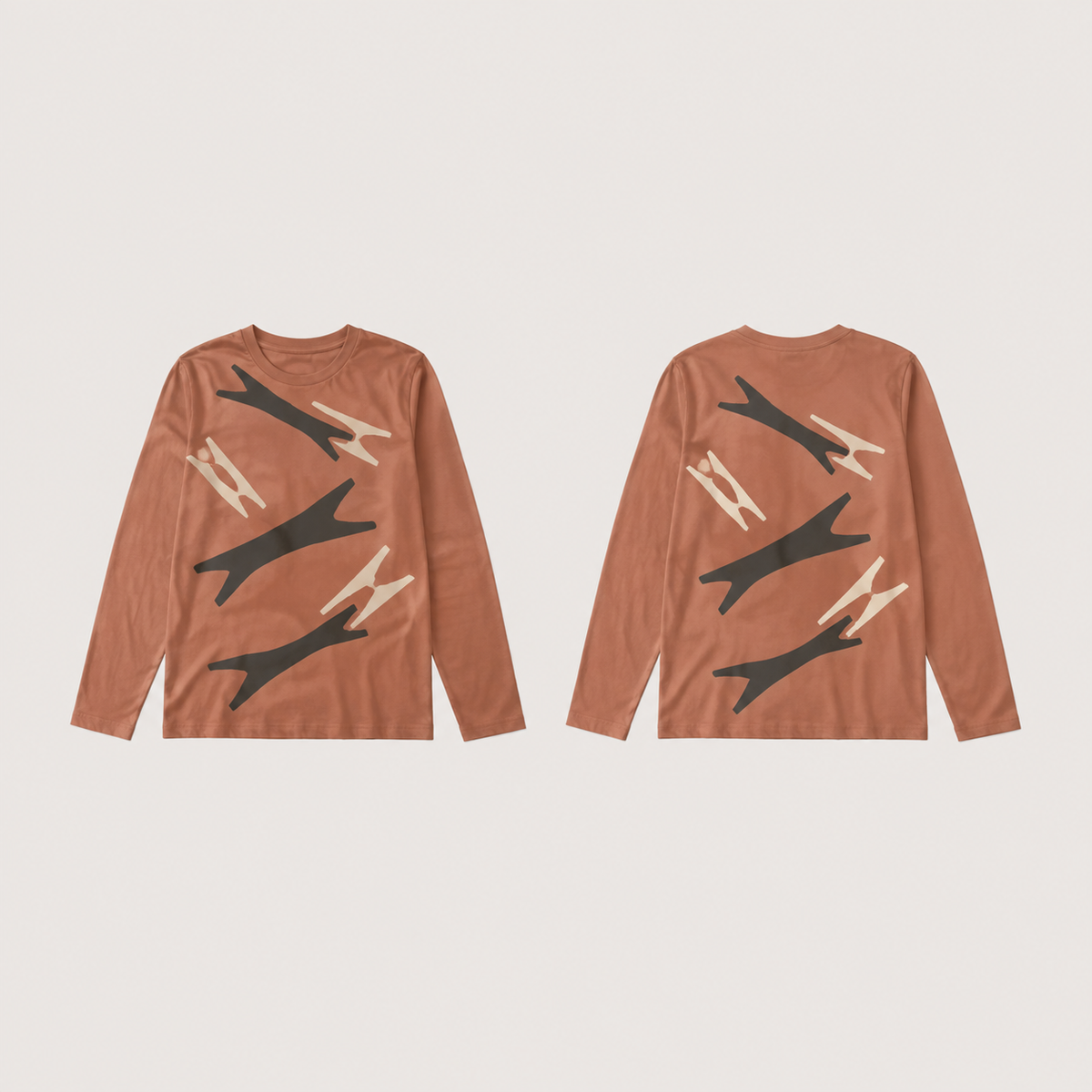 Front and back of a clay long-sleeve tee with large ink fork-ended shapes and cream counterforms separated by open gaps.
