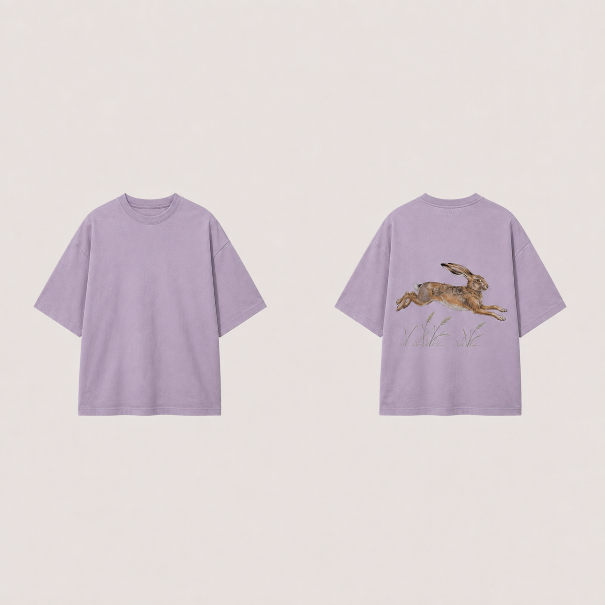 Front and back of a dusty-lilac oversized tee; a natural brown hare bounds above grass on the back, with a plain front.