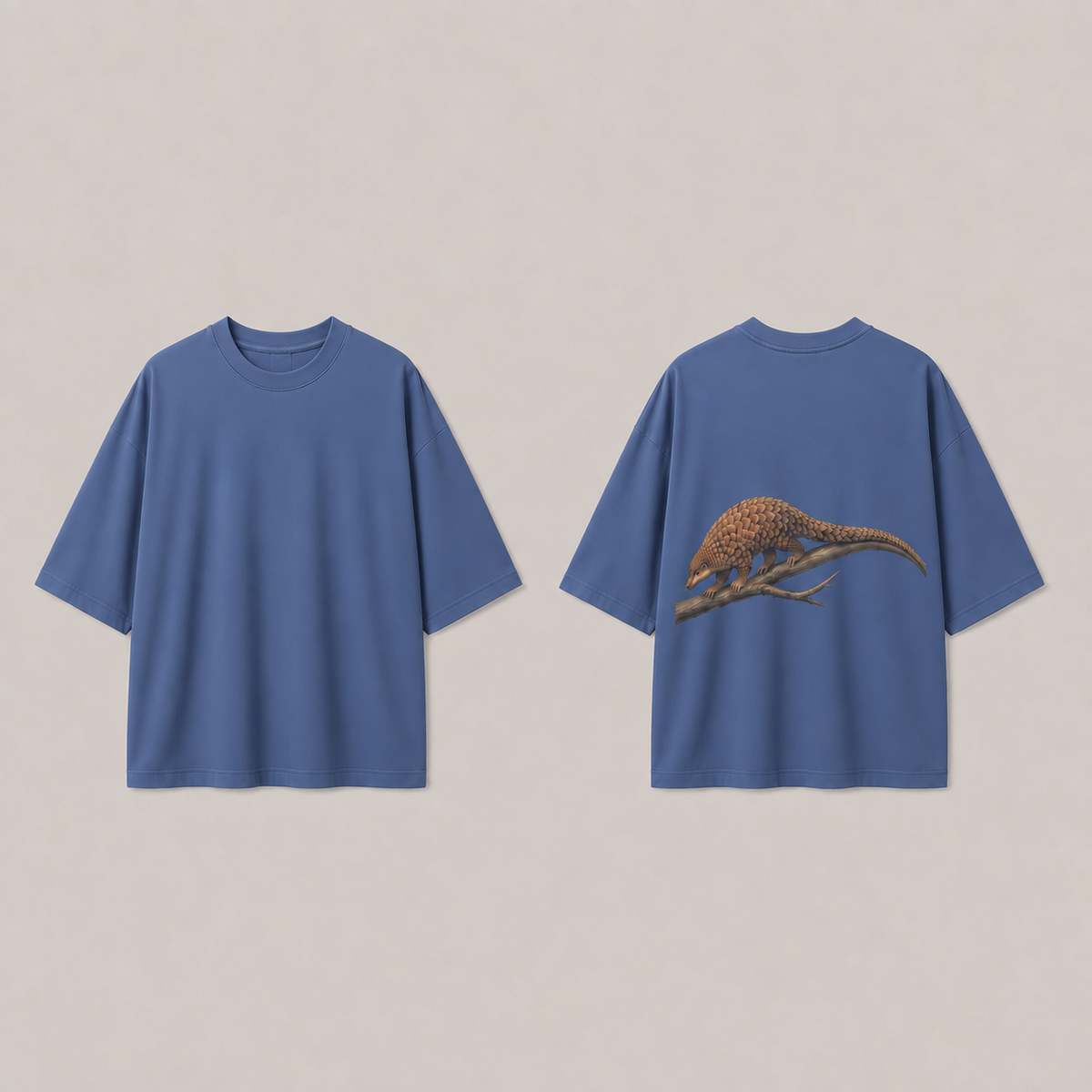 Front and back of a muted cobalt oversized tee with a pangolin and forked branch on the back.