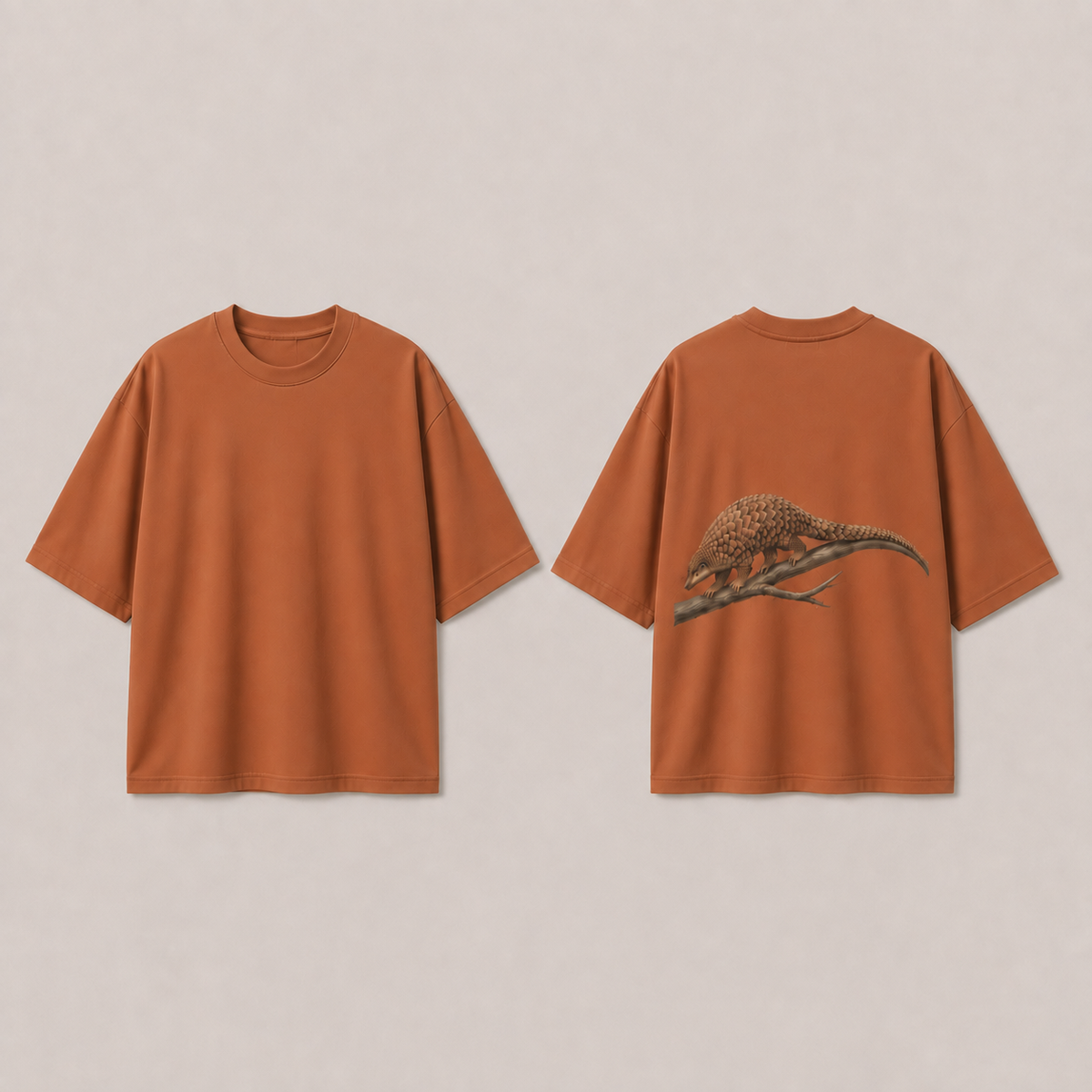 Front and back of a warm clay oversized tee with a pangolin and forked branch on the back.
