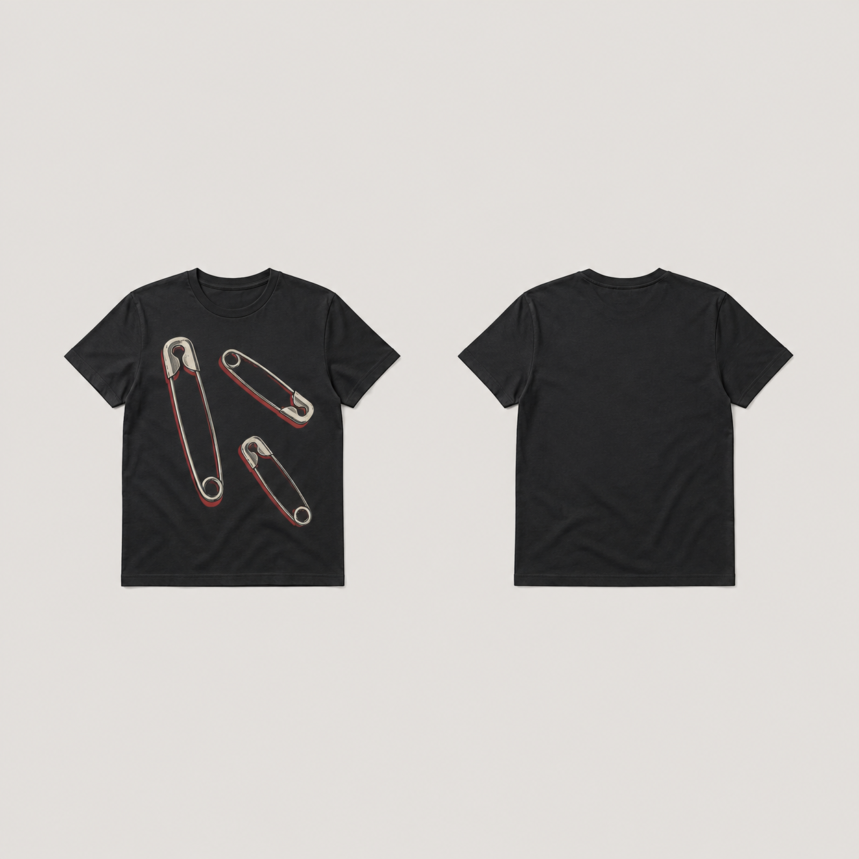 Front and back of a soft-black fitted tee with three closed cream and silver-gray safety-pin illustrations and muted-red shadows on the front.