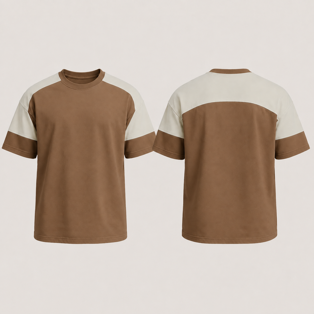 Front and back of a tobacco tee with the same continuous shoulder-spanning saddle in pale stone.