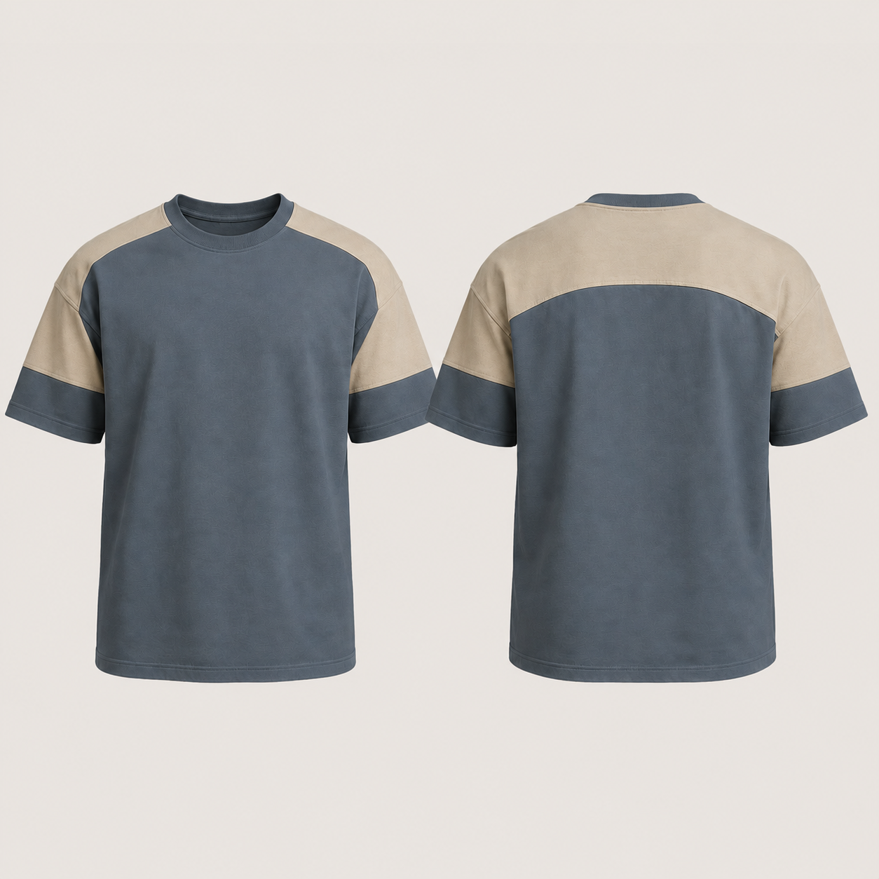 Front and back of a steel-blue tee with a muted-oat saddle panel continuing across the upper back and both sleeve tops.