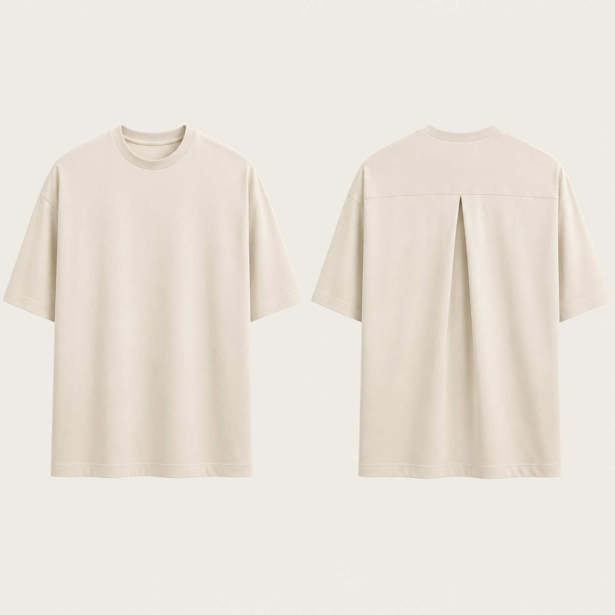 Front and back of a chalk oversized tee with a clear front and one high-back inverted box pleat below a restrained shoulder yoke.