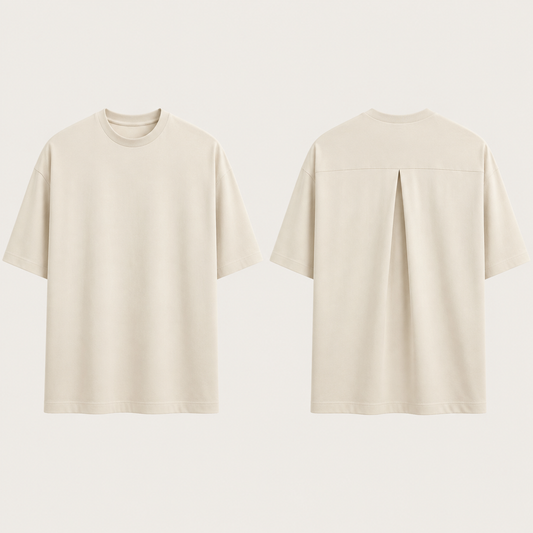 Front and back of a chalk oversized tee with a clear front and one high-back inverted box pleat below a restrained shoulder yoke.