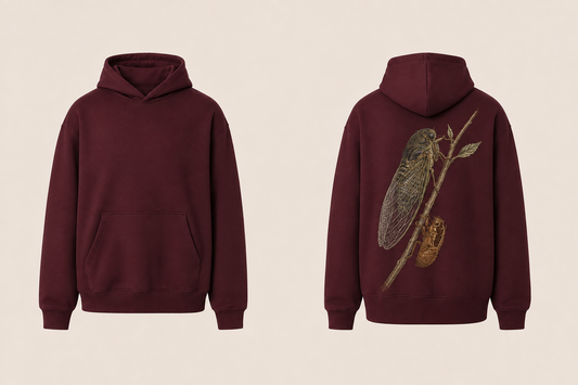Front and back views of a burgundy pullover hoodie with an adult cicada and its hollow amber shed shell clinging to a leafy branch on the back.