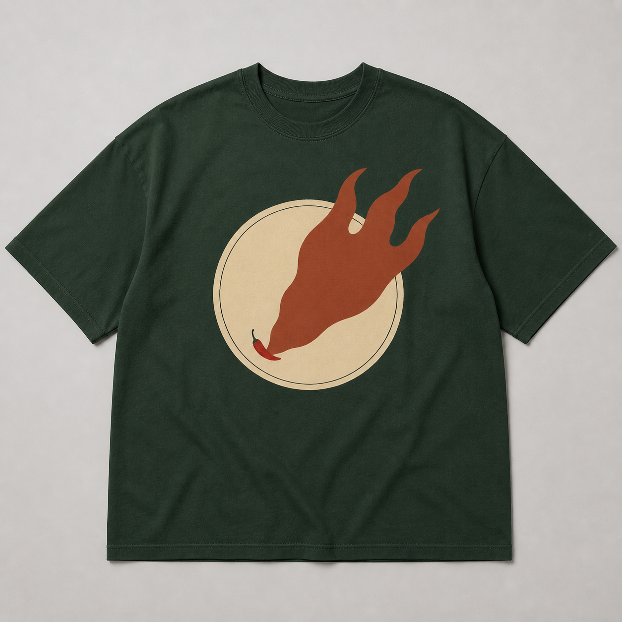 Forest-green oversized tee design with a small red chilli casting an enormous flame-shaped shadow.