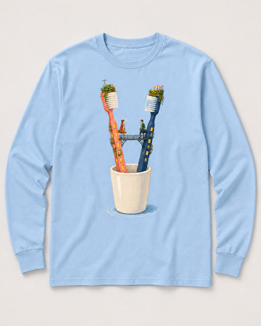 Pale-blue long-sleeve tee design with two toothbrush apartment towers, a bridge, and two people above a bathroom cup.