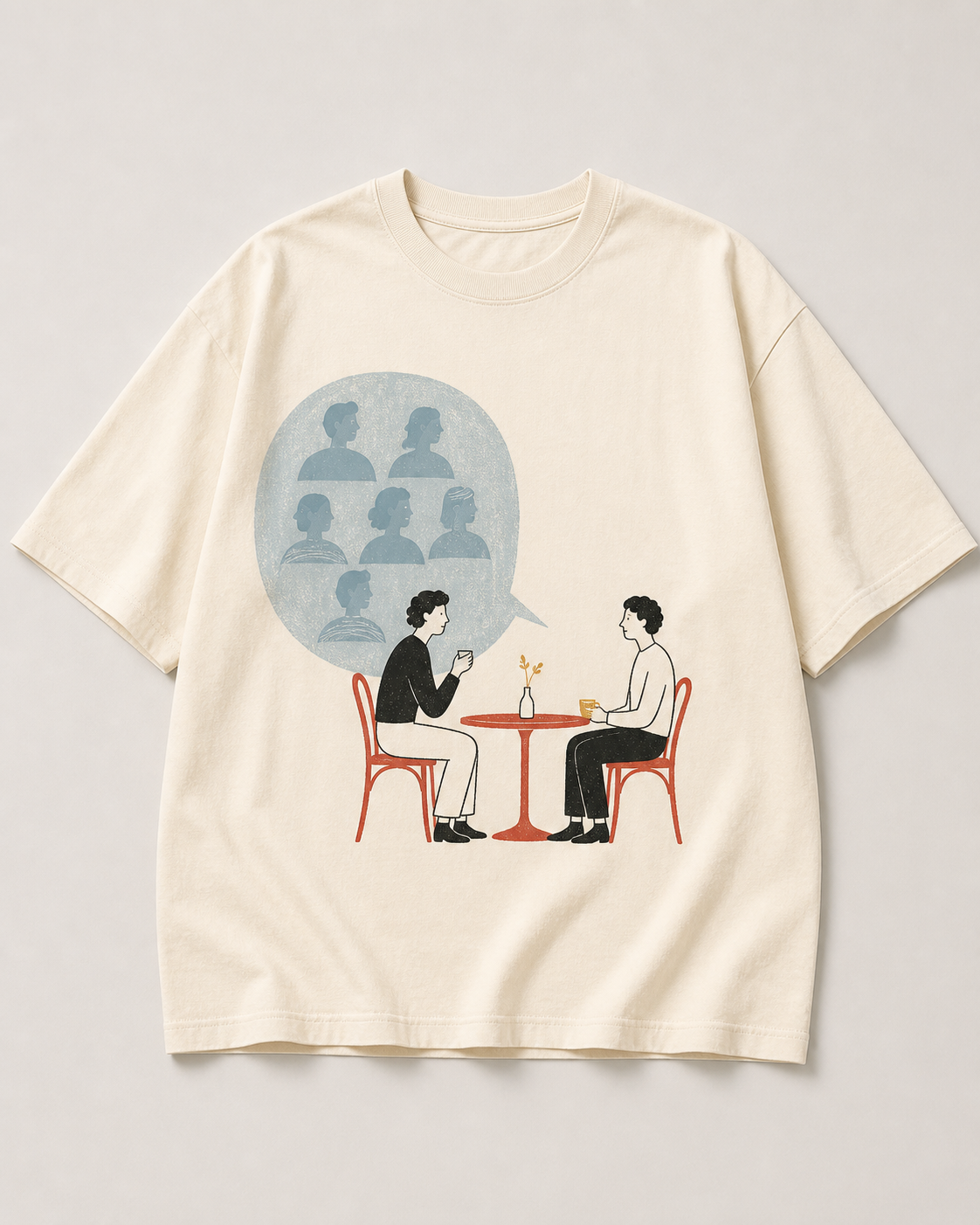 Warm cream oversized tee design with two diners at a red cafe table and six spectators in a pale-blue speech bubble.