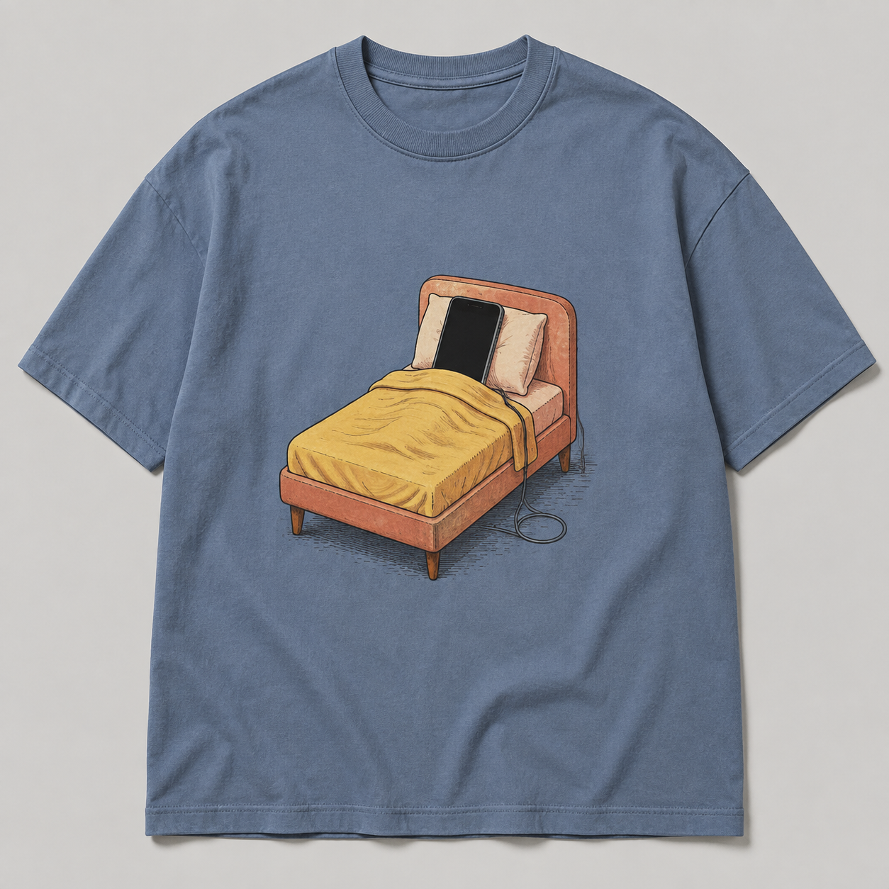 Slate-blue oversized tee design with a phone tucked under a yellow blanket in a coral bed.